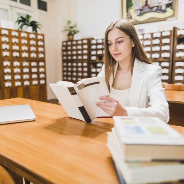 concepto-vuelta-al-cole-mujer-estudiando-libreria